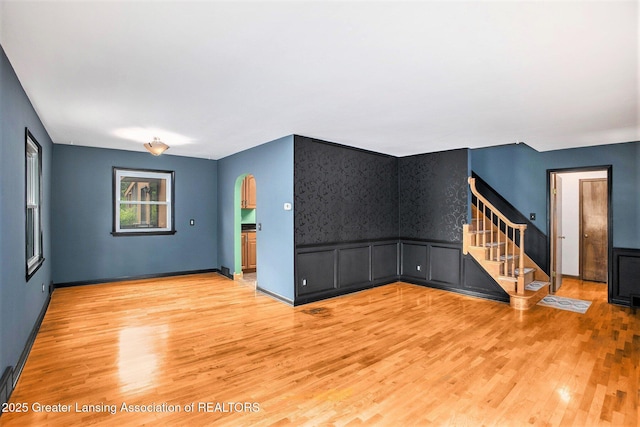 710 Gainsborough Dr, East Lansing, MI 48823 - unfurnished living room with stairway, light wood-type flooring, and baseboards