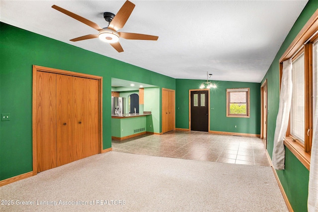 710 Gainsborough Dr, East Lansing, MI 48823 - unfurnished living room featuring ceiling fan, baseboards, and carpet flooring