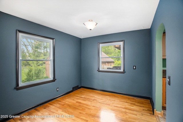 710 Gainsborough Dr, East Lansing, MI 48823 - empty room with arched walkways, light wood-type flooring, and baseboards
