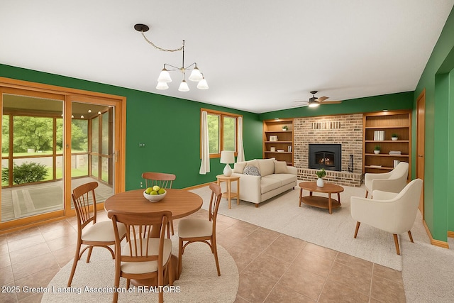 710 Gainsborough Dr, East Lansing, MI 48823 - dining space featuring a ceiling fan, a brick fireplace, light tile patterned floors, and built in features