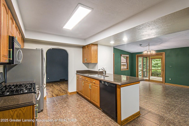 710 Gainsborough Dr, East Lansing, MI 48823 - kitchen featuring appliances with stainless steel finishes, arched walkways, a peninsula, brown cabinets, and a textured ceiling