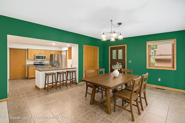 710 Gainsborough Dr, East Lansing, MI 48823 - dining area with a chandelier and light tile patterned floors