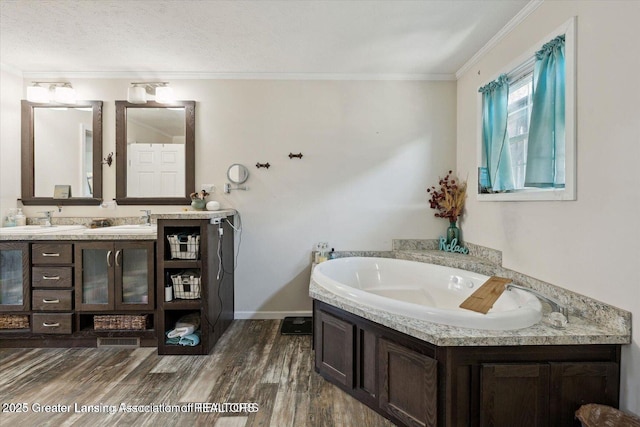 18975 Doyle Ct, Gregory, MI 48137 - full bathroom featuring double vanity, a bath, wood finished floors, crown molding, and baseboards