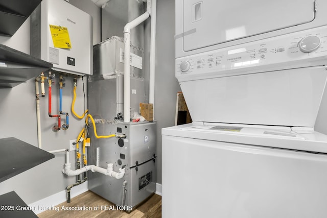 209 Haze St, Lansing, MI 48917 - laundry room with stacked washer / dryer, wood finished floors, and water heater