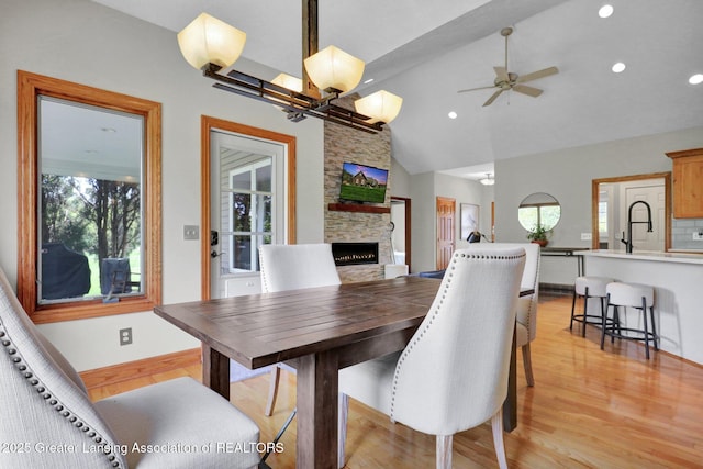 4740 Round Lake Rd, Laingsburg, MI 48848 - dining area with a fireplace, light wood-style flooring, lofted ceiling, ceiling fan, and recessed lighting
