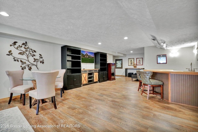 4740 Round Lake Rd, Laingsburg, MI 48848 - indoor bar featuring a textured ceiling, light wood-style floors, recessed lighting, and baseboards