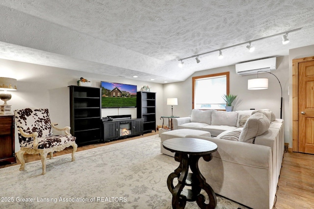 4740 Round Lake Rd, Laingsburg, MI 48848 - living area featuring rail lighting, wood finished floors, a wall mounted AC, a textured ceiling, and recessed lighting