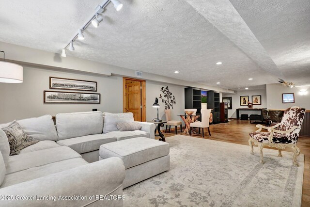 4740 Round Lake Rd, Laingsburg, MI 48848 - living room with a textured ceiling, wood finished floors, recessed lighting, and rail lighting