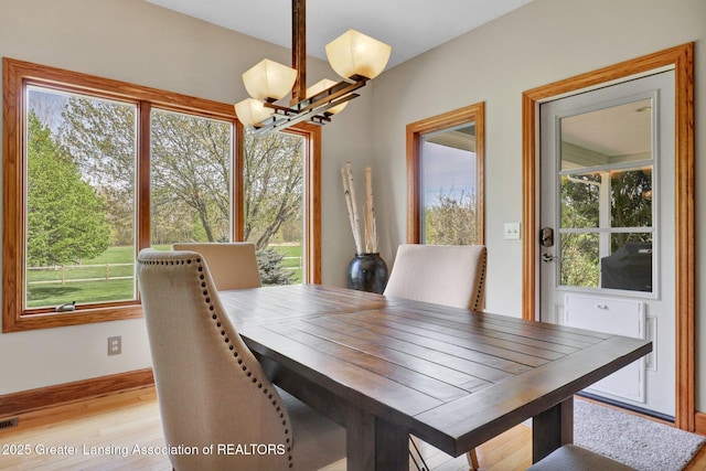 4740 Round Lake Rd, Laingsburg, MI 48848 - dining room featuring a chandelier, plenty of natural light, light wood finished floors, and baseboards