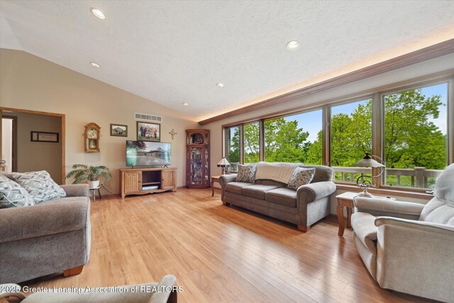 10949 Lakeside Dr, Perrinton, MI 48871 - living area with lofted ceiling, healthy amount of natural light, light wood-style floors, recessed lighting, and a textured ceiling