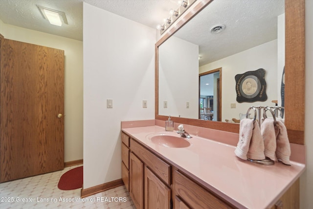 10949 Lakeside Dr, Perrinton, MI 48871 - bathroom with a textured ceiling, vanity, tile patterned floors, and baseboards