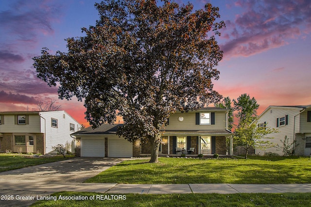 3229 Inverary Dr, Lansing, MI 48911 - traditional home with covered porch, an attached garage, driveway, and a front yard