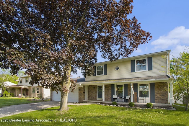 3229 Inverary Dr, Lansing, MI 48911 - traditional home with concrete driveway, covered porch, an attached garage, a front yard, and brick siding