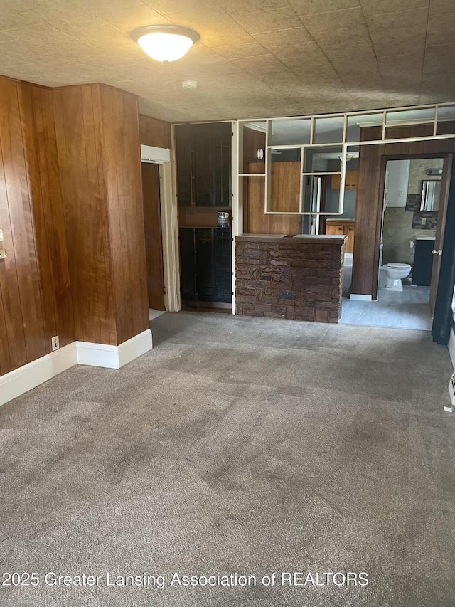 1846 Davis Ave, Lansing, MI 48910 - unfurnished living room featuring carpet and wooden walls