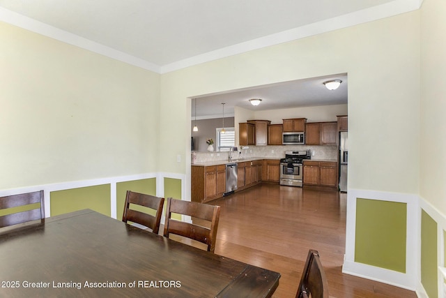 15145 Nottingham Fields Pkwy, Lansing, MI 48906 - dining space featuring dark wood-type flooring and crown molding