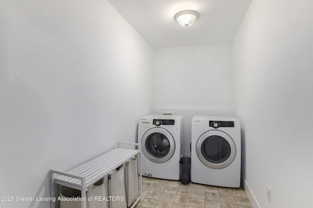 15145 Nottingham Fields Pkwy, Lansing, MI 48906 - laundry room featuring washer and clothes dryer, baseboards, and light stone finish flooring