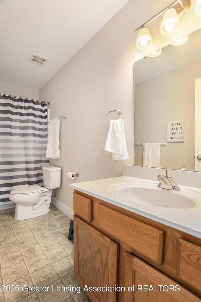 15145 Nottingham Fields Pkwy, Lansing, MI 48906 - bathroom with toilet, vanity, and baseboards