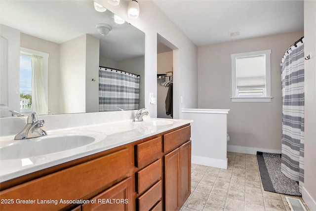 15145 Nottingham Fields Pkwy, Lansing, MI 48906 - bathroom with plenty of natural light, baseboards, double vanity, and toilet