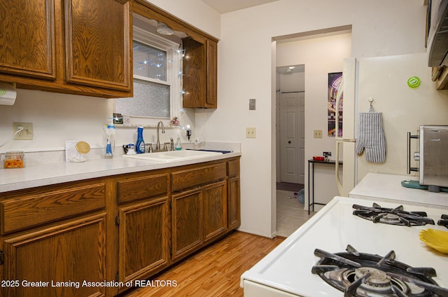 37936 Watkins Dr Unit 32, Sterling Heights, MI 48312 - kitchen featuring a sink, light countertops, gas range gas stove, and light wood-style flooring