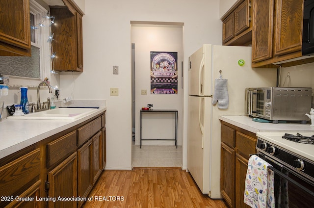37936 Watkins Dr Unit 32, Sterling Heights, MI 48312 - kitchen featuring a sink, light countertops, black microwave, light wood-style floors, and baseboards