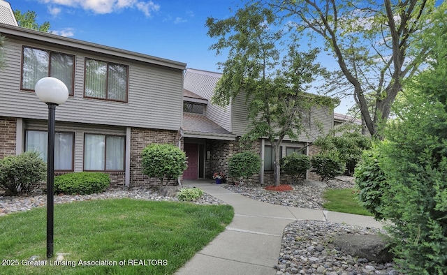 1046 Grenoble Ln Unit D, Lansing, MI 48917 - view of property featuring brick siding and a front lawn