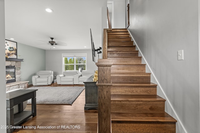 1600 Tuttle Rd, Mason, MI 48854 - stairs featuring ceiling fan, wood finished floors, a fireplace, recessed lighting, and baseboards