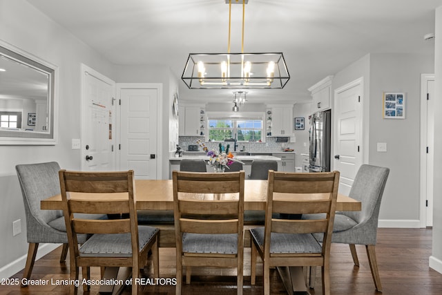 1600 Tuttle Rd, Mason, MI 48854 - dining area featuring dark wood finished floors, a chandelier, and baseboards