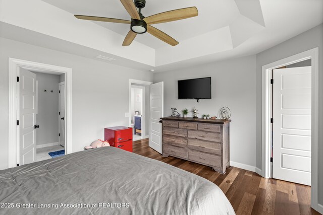 1600 Tuttle Rd, Mason, MI 48854 - bedroom with a tray ceiling, wood finished floors, baseboards, and a ceiling fan