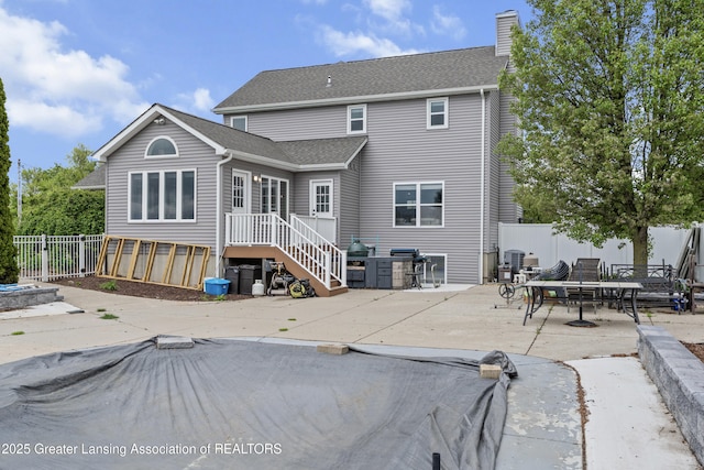 1600 Tuttle Rd, Mason, MI 48854 - back of house featuring a patio area, a chimney, and roof with shingles