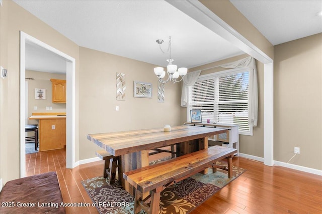 703 Hastay Blvd, Eaton Rapids, MI 48827 - dining room featuring light wood-style flooring, baseboards, and a chandelier