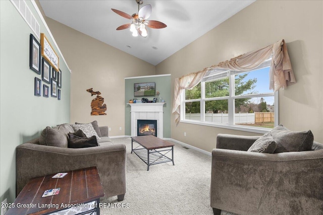 703 Hastay Blvd, Eaton Rapids, MI 48827 - carpeted living area with vaulted ceiling, a tile fireplace, ceiling fan, and baseboards