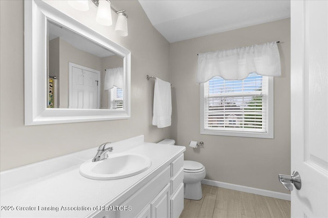 703 Hastay Blvd, Eaton Rapids, MI 48827 - bathroom with vanity, toilet, baseboards, and wood finished floors
