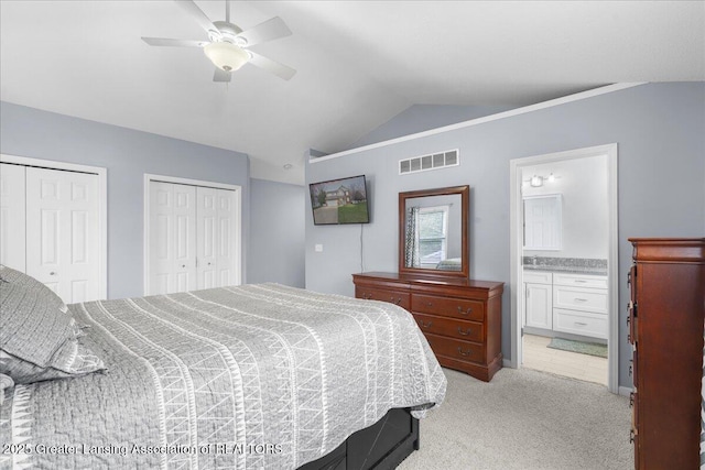 703 Hastay Blvd, Eaton Rapids, MI 48827 - bedroom with vaulted ceiling, two closets, light colored carpet, ensuite bathroom, and a ceiling fan