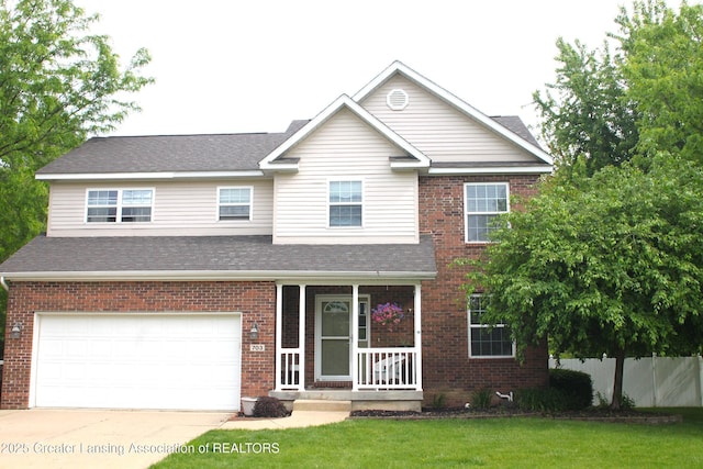703 Hastay Blvd, Eaton Rapids, MI 48827 - traditional-style house with an attached garage, a porch, driveway, and brick siding