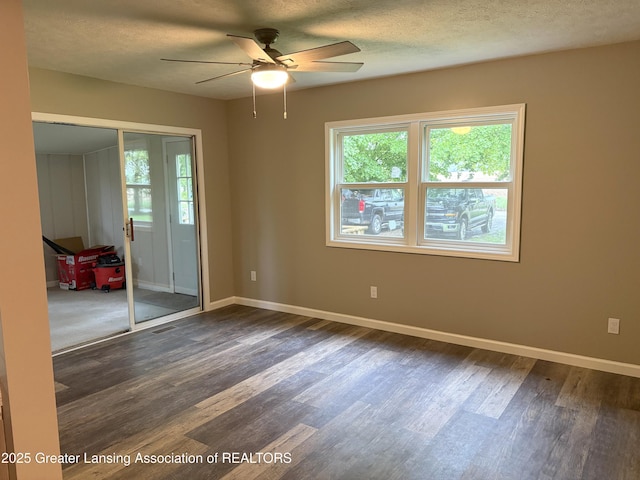 4684 Sherman Rd, Charlotte, MI 48813 - empty room with healthy amount of natural light, dark wood-style flooring, a ceiling fan, baseboards, and a textured ceiling
