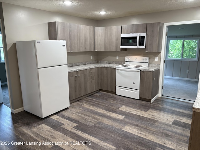 4684 Sherman Rd, Charlotte, MI 48813 - kitchen featuring white appliances, a textured ceiling, dark wood-style flooring, and baseboards