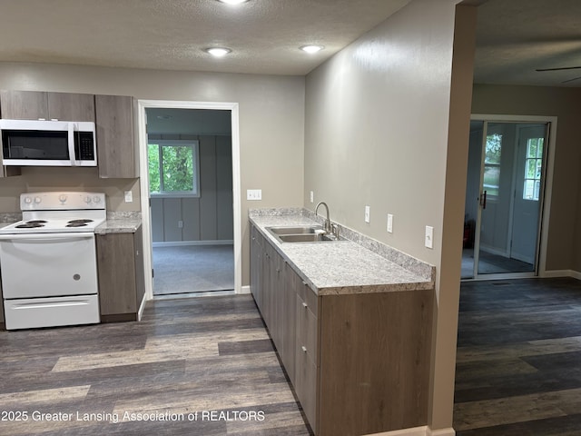 4684 Sherman Rd, Charlotte, MI 48813 - kitchen featuring stainless steel microwave, white electric range, a sink, dark wood finished floors, and a textured ceiling