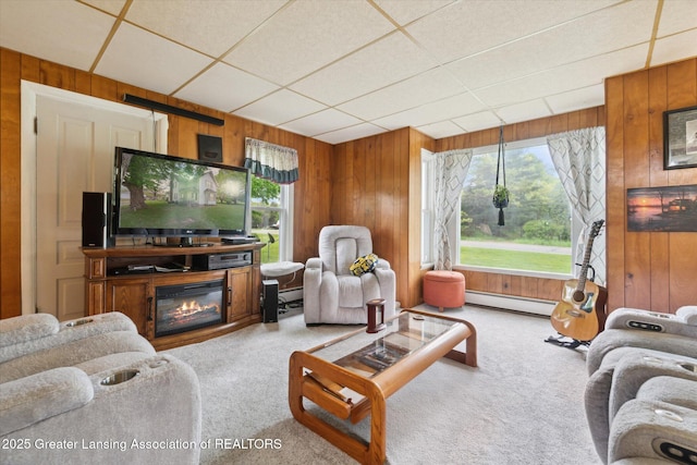 6275 E Clark Rd, Bath, MI 48808 - living area with wood walls, baseboard heating, carpet flooring, a glass covered fireplace, and a drop ceiling