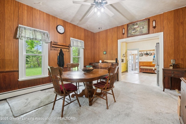 6275 E Clark Rd, Bath, MI 48808 - dining area with wooden walls, ceiling fan, light colored carpet, and a baseboard heating unit