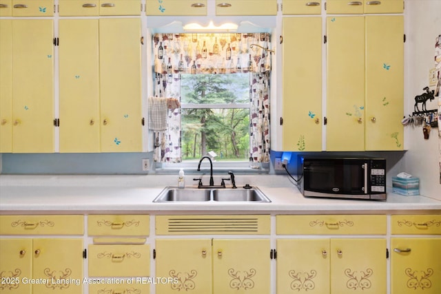 6275 E Clark Rd, Bath, MI 48808 - kitchen with a sink, light countertops, and cream cabinets