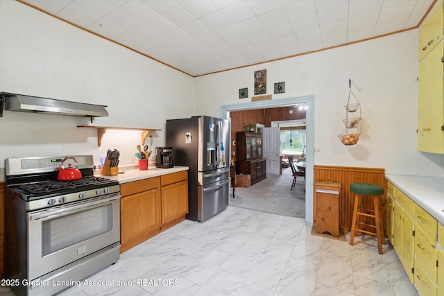6275 E Clark Rd, Bath, MI 48808 - kitchen with appliances with stainless steel finishes, exhaust hood, light countertops, wainscoting, and light marble finish flooring