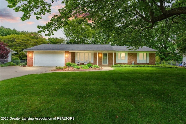 14921 Karl Dr, Lansing, MI 48906 - ranch-style house with an attached garage, driveway, and brick siding