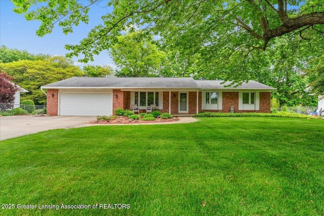 14921 Karl Dr, Lansing, MI 48906 - ranch-style house featuring an attached garage, concrete driveway, and brick siding