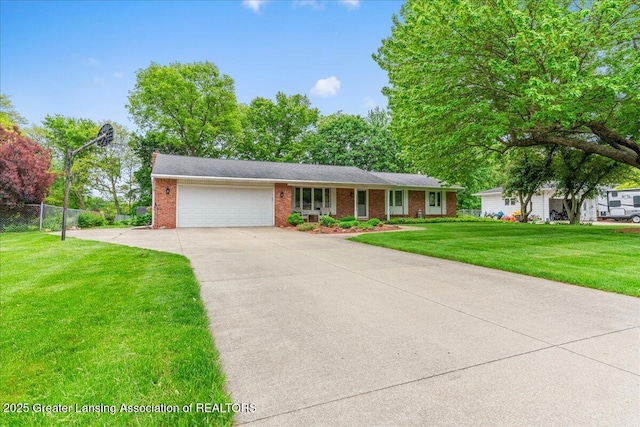 14921 Karl Dr, Lansing, MI 48906 - view of front of home featuring concrete driveway, a garage, brick siding, and a chimney