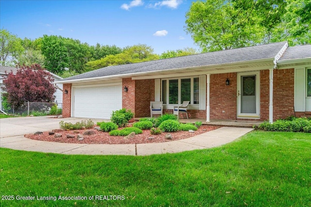 14921 Karl Dr, Lansing, MI 48906 - ranch-style home with brick siding, covered porch, a front yard, and an attached garage