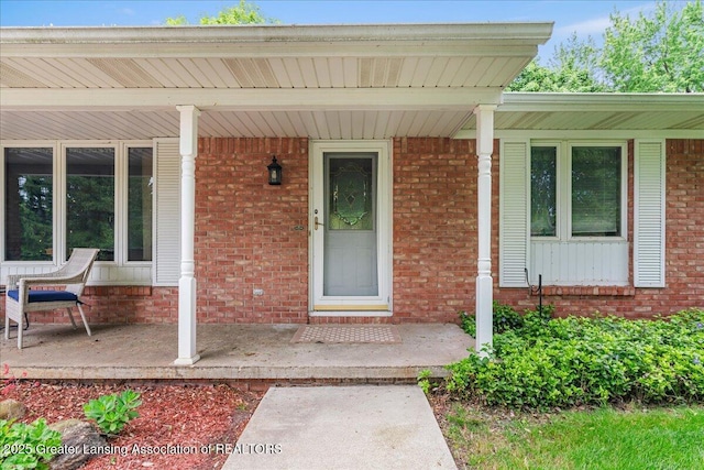 14921 Karl Dr, Lansing, MI 48906 - property entrance featuring covered porch and brick siding