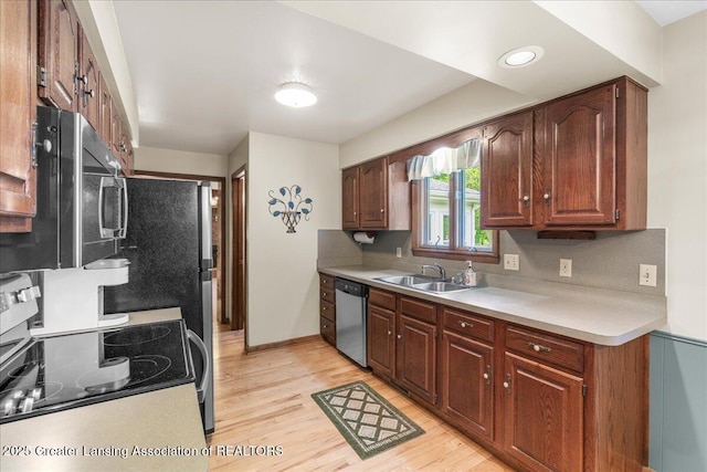14921 Karl Dr, Lansing, MI 48906 - kitchen featuring appliances with stainless steel finishes, a sink, light wood-type flooring, and light countertops
