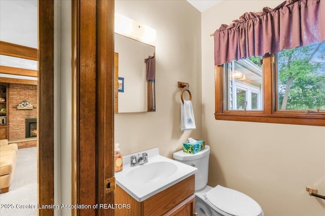 14921 Karl Dr, Lansing, MI 48906 - bathroom featuring vanity, toilet, and a fireplace
