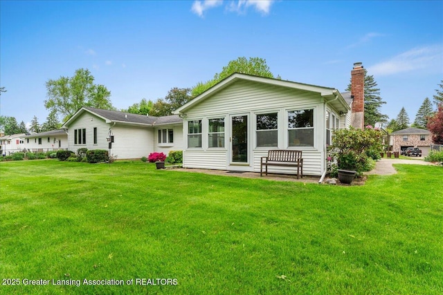 14921 Karl Dr, Lansing, MI 48906 - rear view of house featuring a chimney and a yard