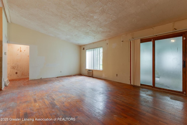4316 Dumfries Cir, Lansing, MI 48911 - spare room with hardwood / wood-style flooring, a wall unit AC, and a textured ceiling
